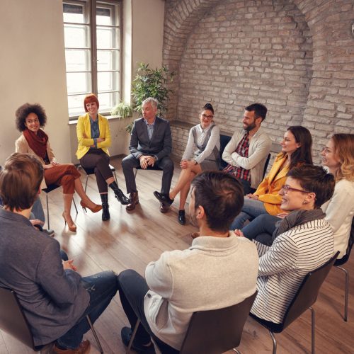 Business people talking at group meeting in circle